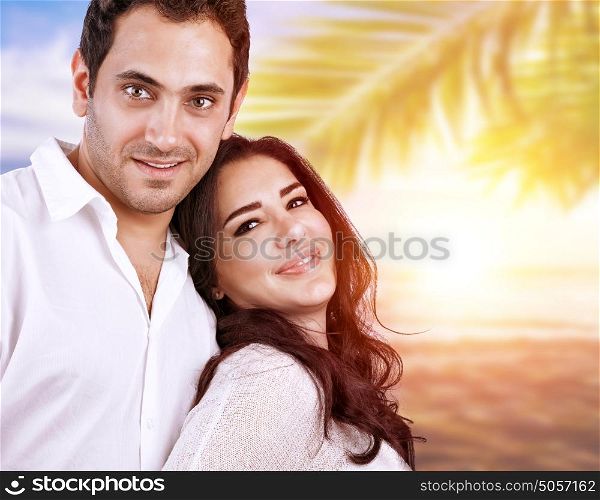Closeup portrait of beautiful satisfied couple hugging outdoors in sunset light, spending honeymoon on tropical resort, summer vacation in love