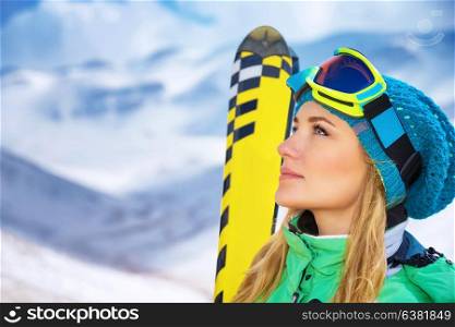 Closeup portrait of beautiful skier girl wearing mask and holding ski, enjoying winter holidays in Europe