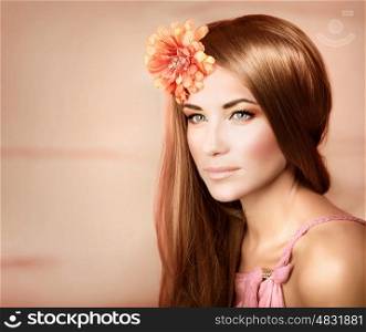 Closeup portrait of beautiful woman with shiny hair and fresh orange flower in it, studio shot, fashion and style, luxury beauty salon