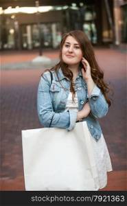 Closeup portrait of beautiful woman with shopping bag on street