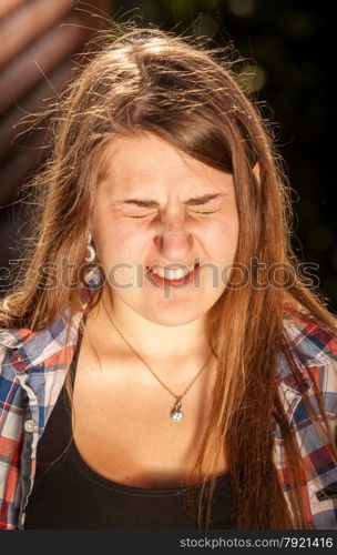 Closeup portrait of brunette woman wincing of bright light