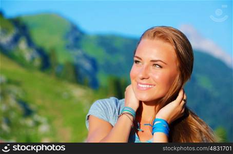 Closeup portrait of charming girl enjoying sunny day in Alpine mountains, having fun outdoors, trekking and hiking concept