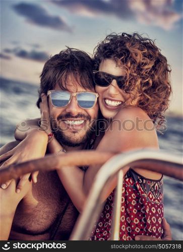 Closeup portrait of cheerful happy lovers on sailboat, young couple having fun in romantic sea traveling, love and enjoyment concept