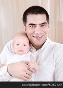 Closeup portrait of cheerful young father hugging adorable newborn child, happy fatherhood, love and happiness concept