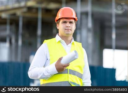 Closeup portrait of construction manager posing against scaffolding