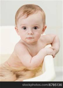 Closeup portrait of cute baby boy bathing and looking at camera
