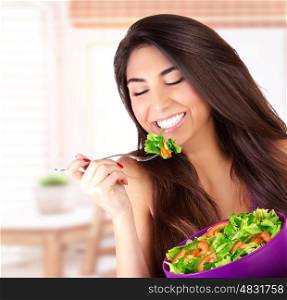 Closeup portrait of cute girl eating salad on the kitchen, enjoying fresh tasty vegetables with closed eyes, healthy lifestyle concept