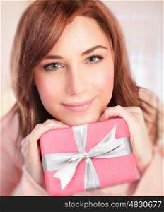 Closeup portrait of cute girl with pink gift box at home, receive present in Valentine day, happy romantic holiday