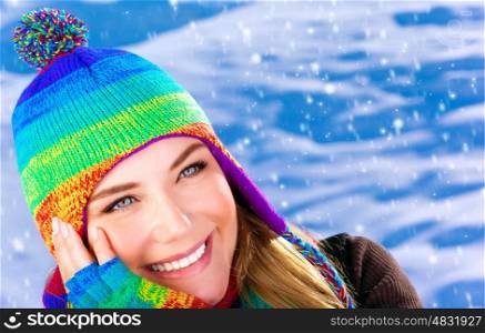 Closeup portrait of cute happy woman wearing warm colorful hat on snowing background, wintertime fashion style, cold weather concept