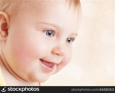 Closeup portrait of cute little baby girl over beige blur background, adorable child face, nice innocent kid, happy carefree childhood