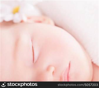Closeup portrait of cute little baby sleep, face part, gentle daisy flower decoration, carefree childhood, purity and innocence concept