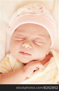 Closeup portrait of cute little baby sleeping in pink pajama &amp; hat