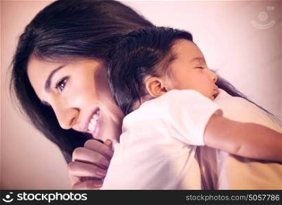 Closeup portrait of cute little baby sleeping on mothers shoulder, happy young loving family, new life concept