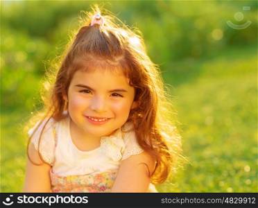 Closeup portrait of cute little girl on green grass field, having fun outdoors, summer holidays, active childhood, happiness concept