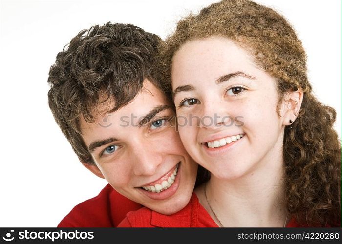 Closeup portrait of cute teen boy and girl with perfect teeth, against a white background.