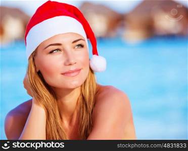 Closeup portrait of cute woman wearing red Santa hat, celebrating Christmas holidays on Maldive islands, New Year party on the beach