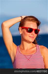 Closeup portrait of cute woman wearing red stylish sunglasses, relaxation om the beach, retro style look, summer vacation, happiness concept