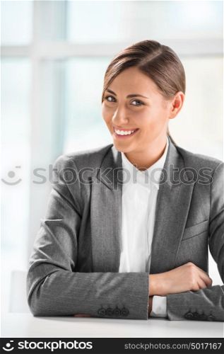 Closeup portrait of cute young business woman smiling at her office