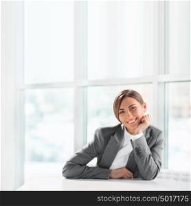 Closeup portrait of cute young business woman smiling at her office