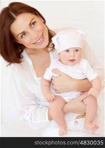 Closeup portrait of cute young mother holding sweet newborn baby, at home, happy family, love and new life concept