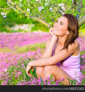 Closeup portrait of dreamy woman spending time in blooming park, watching for first blossom of nature, happy weekend in countryside, relaxation outdoors