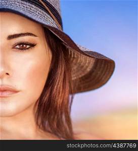 Closeup portrait of gorgeous beautiful arabic woman with perfect makeup wearing stylish hat on the beach, half face, fashion and beauty