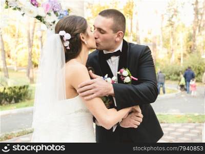 Closeup portrait of happy bride and groom kissing first time at ceremony