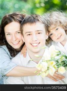 Closeup portrait of happy family in spring park against natural green background