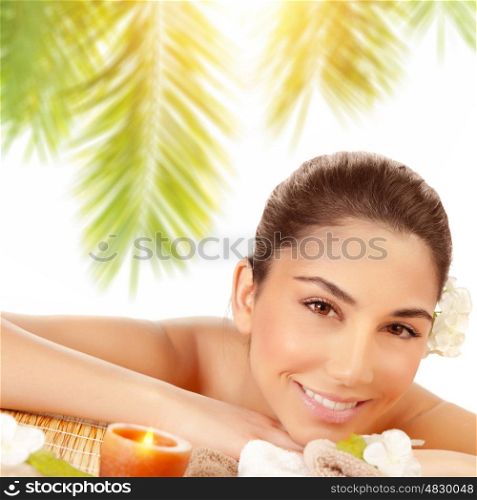 Closeup portrait of happy woman lying down on massage table on tropical beach in sunny day, enjoying day spa, relaxation outdoors, beauty treatment&#xA;