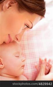 Closeup portrait of little adorable child sleeping with beautiful young mother, resting at home, loving family, tenderness concept