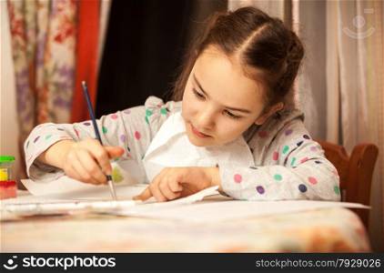 Closeup portrait of little girl drawing on canvas