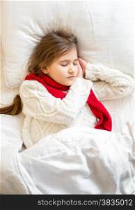 Closeup portrait of little girl in sweater sleeping at bed