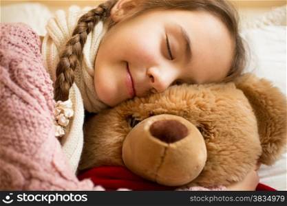 Closeup portrait of little girl sleeping on brown teddy bear