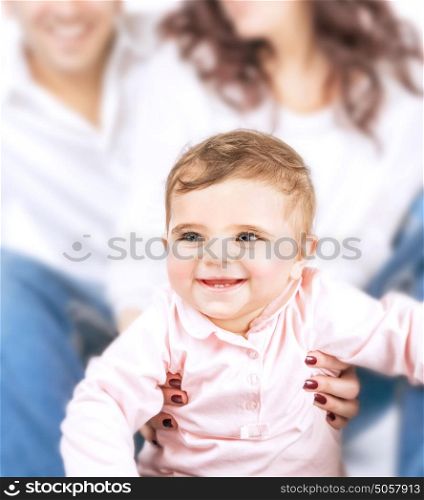 Closeup portrait of little smiling child and soft focus of parents, joyful family, happy parenthood, love and happiness concept