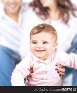 Closeup portrait of little smiling child and soft focus of parents, joyful family, happy parenthood, love and happiness concept