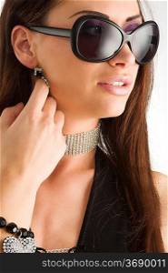 closeup portrait of pretty brunette with long dark hair sunglasses and jewellery