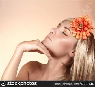 Closeup portrait of pretty girl with closed eyes isolated on beige background, orange flower, autumn season, luxury spa salon