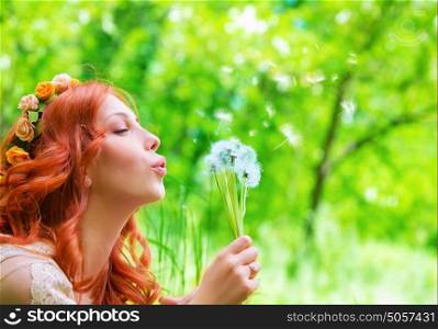 Closeup portrait of pretty woman blowing on dandelion, having fun on fresh green park in sunny day, enjoying spring season