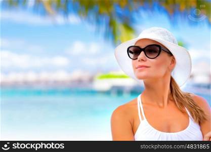 Closeup portrait of pretty woman standing on seashore and looking into the distance, enjoying beach resort on Maldives
