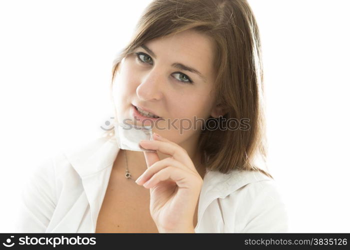 Closeup portrait of sexy brunette woman tearing condom by teeth
