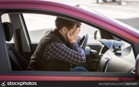 Closeup portrait of shocked male driver closing face with hands