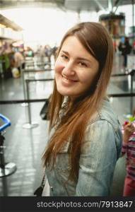 Closeup portrait of smiling brunette woman standing at queue in airport