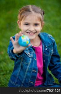 Closeup portrait of smiling girl holding globe in hand