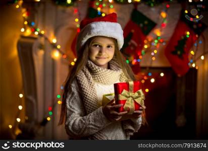 Closeup portrait of smiling girl opening sparkling gift box at Christmas