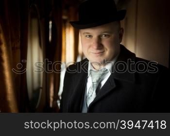 Closeup portrait of smiling man in bowler hat posing in retro train