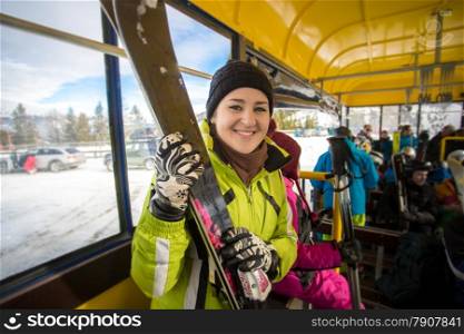Closeup portrait of smiling woman riding in bus with skis