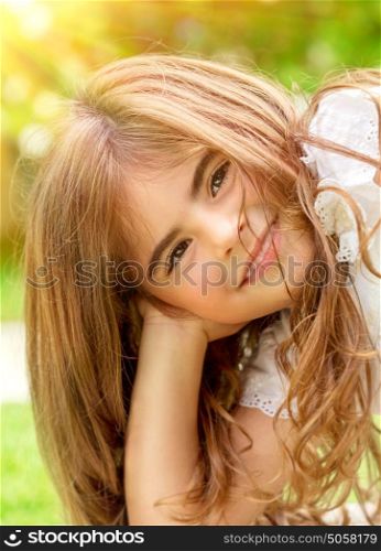 Closeup portrait of sweet little child outdoors, cute Arabic girl enjoying warm sunny summer day, happy and carefree childhood concept