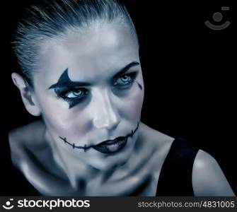 Closeup portrait of terrifying witch with creepy makeup and aggressive look, isolated on black background, Halloween party concept