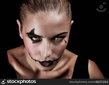 Closeup portrait of terrifying witch with creepy makeup and aggressive look, isolated on black background, Halloween party concept