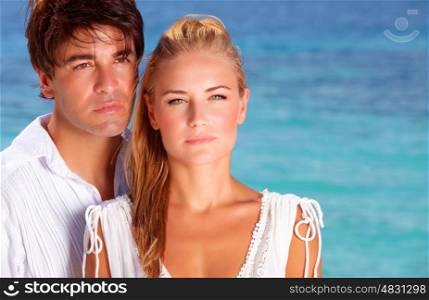 Closeup portrait of two serious young people spending summer holidays on the sea, young family in romantic vacation